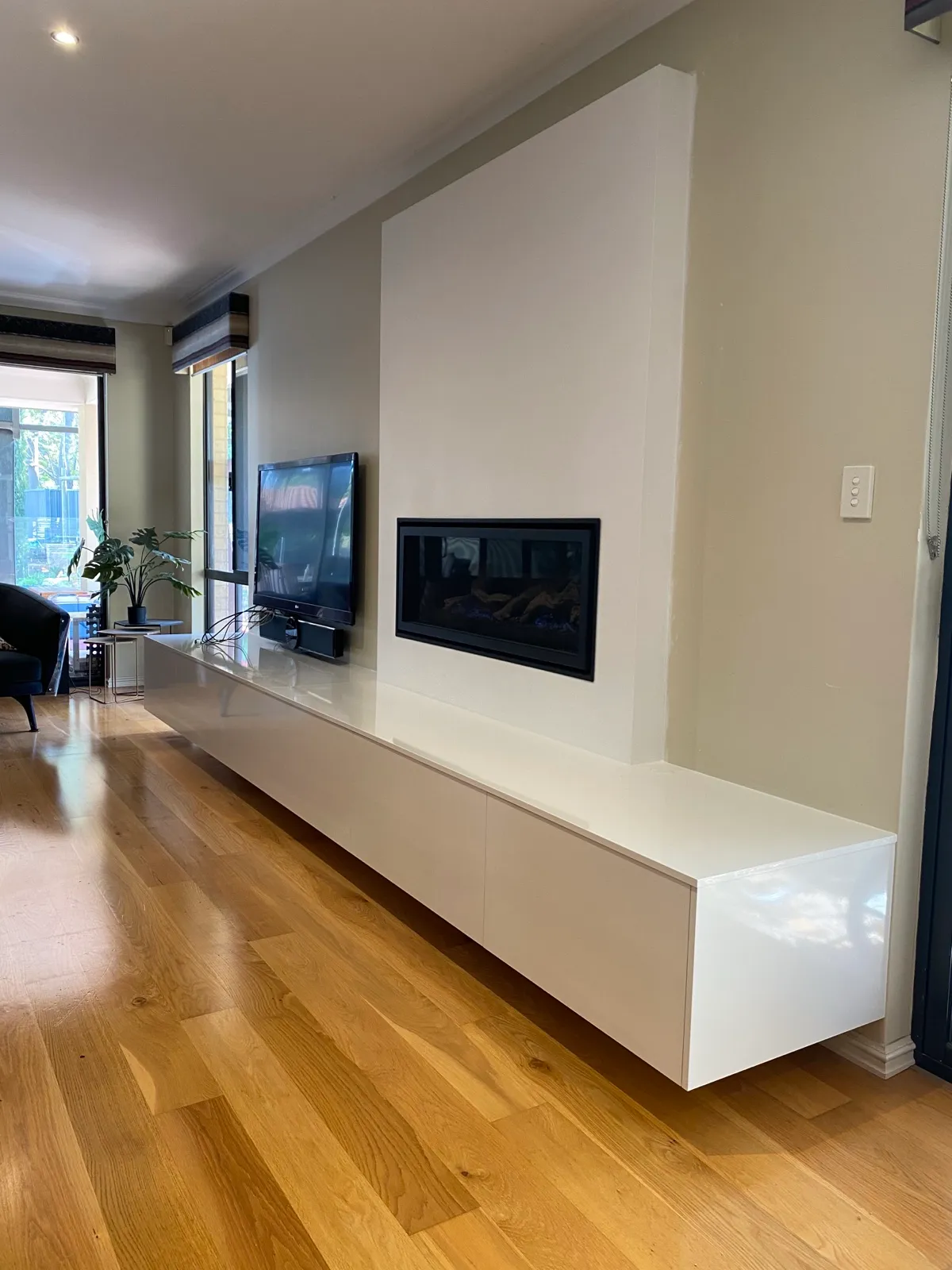 Floating media unit below fireplace