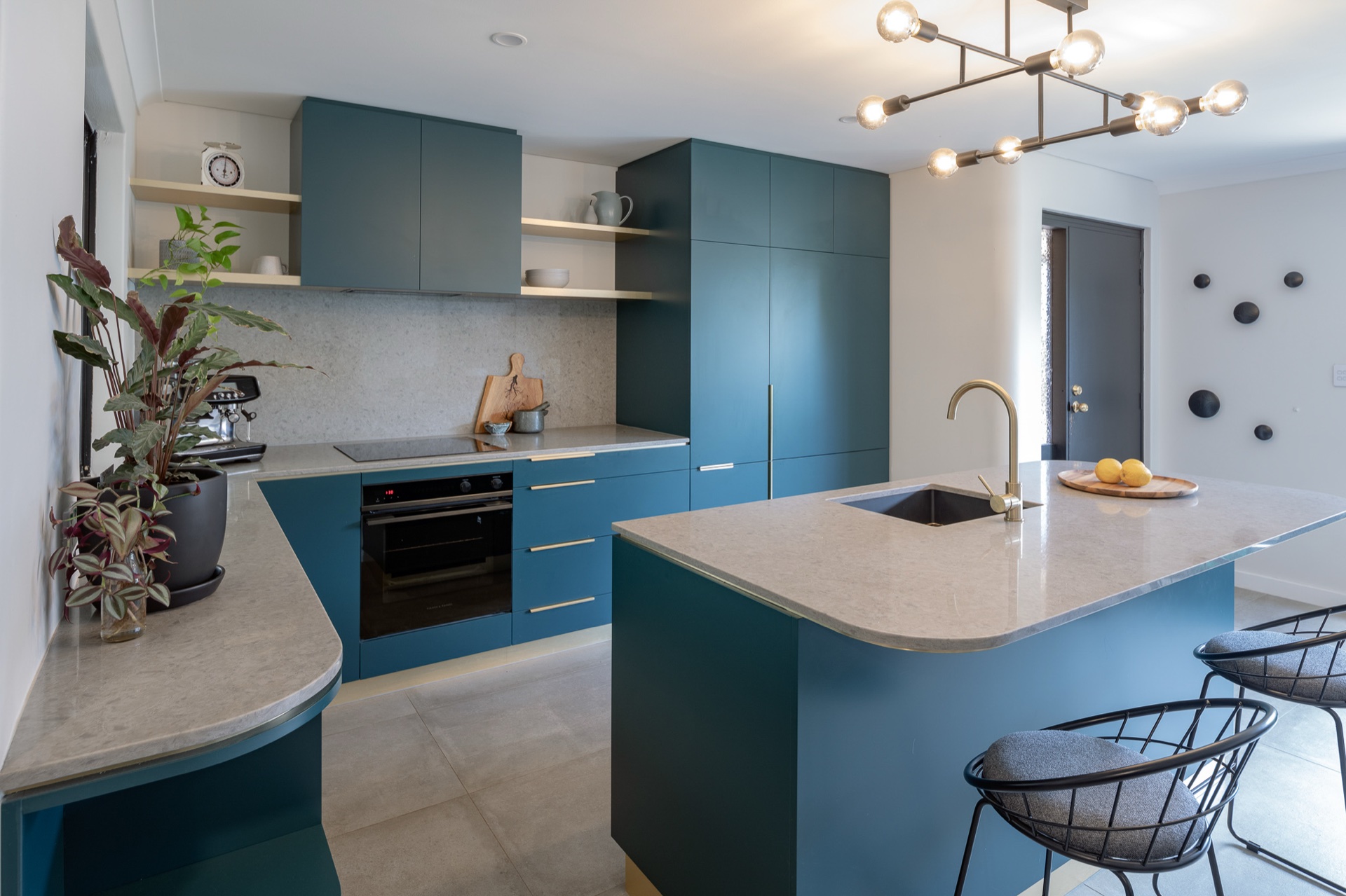 Teal kitchen island with brass tapware